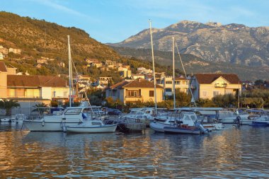 Resimli bir sonbahar Akdeniz manzarası. Karadağ, Adriyatik Denizi, Kotor Körfezi. Tivat şehrindeki Marina Kalimanj manzarası ve Lovcen dağları