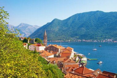 Güneşli sonbahar gününde Aziz Niklas Kilisesi 'nin çan kulesiyle antik Perast kasabası manzarası. Karadağ, Adriyatik Denizi, Kotor Körfezi