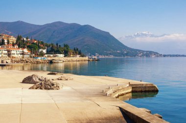 Güzel bir kış Akdeniz manzarası. Karadağ. Herceg Novi şehri yakınlarındaki Kotor Körfezi manzarası. Uzakta Lovcen dağları karla kaplı.