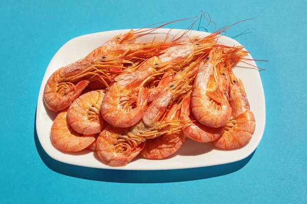 Plato Con Gambas Rosadas Hervidas Sobre Fondo Azul —  Fotos de Stock