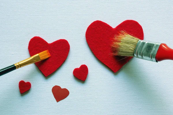 バレンタイン キャンバスに2つのペイントブラシで異なるサイズの赤の心の描画 テックスのためのフリースペース — ストック写真