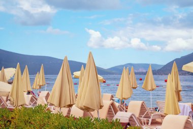 Sonbahar kumsal tatili. Karadağ, Tivat. Kotor Körfezi kıyısı, şezlonglar ve plaj şemsiyeleri.