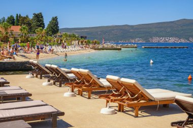 Tivat, Montenegro - July 10, 2025: Summer beach vacation. Montenegro, Adriatic Sea. Beach on coast of Bay of Kotor near Tivat city