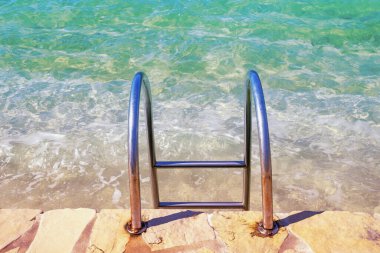 Güneşli bir günde sahile inmek için metal merdiven. Karadağ, Adriyatik Denizi