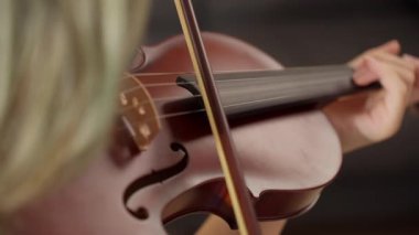Kadın keman çalıyor.