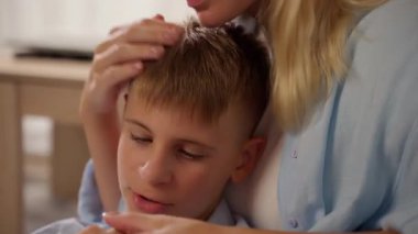 Anne ve oğlunun evde sarılıp yattıkları portre.