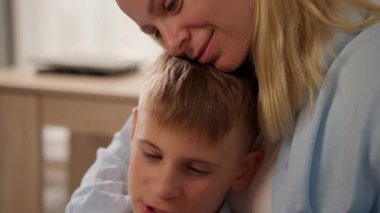 Genç bir adam sabah oğlunu kucaklıyor, sarılıyor ve öpüyor.