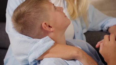 Anne ve oğlu evdeki kanepede televizyon izliyorlar. yüksek kaliteli fotoğraf