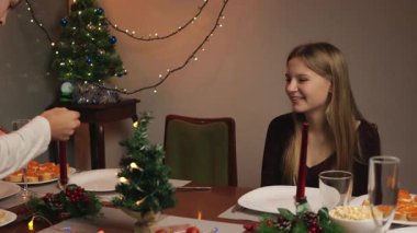 Genç bir çift Noel yemeğini evde yiyor.