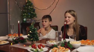 Genç ve mutlu bir aile akşam yemeği yiyor..