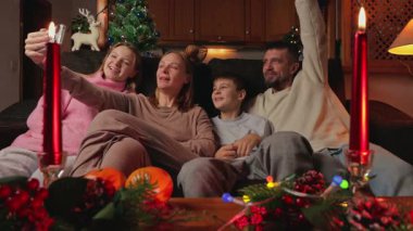 Noel ağacında tabletli mutlu aile ve video çağrısı