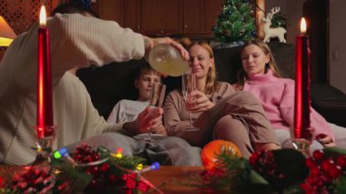 Mutlu bir aile Noel arifesinde evde içki içiyor.