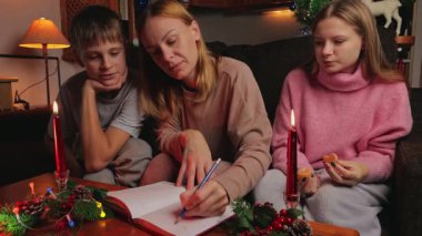 Mutlu aile kitapları evde Noel için okunur.