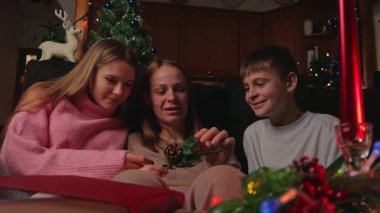 Noel ağacında dört kişilik bir aile ve küçük bir kız çocuğu..