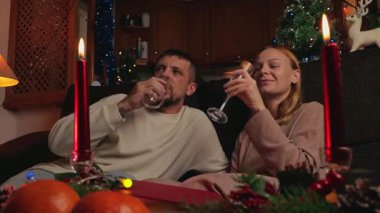 Genç bir çift Noel akşamı şarap içiyor.