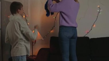 Genç bir aile ve oğlu Noel ağacında oynuyorlar.