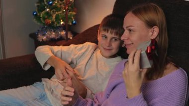 Genç bir anne ve oğlu Noel akşamı televizyon izliyor..