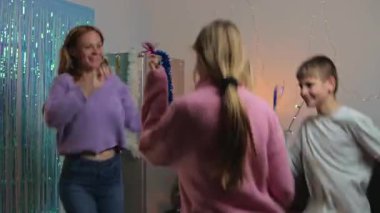 Mutlu genç bir aile evde eğleniyor, Noel ağacıyla oynuyor..