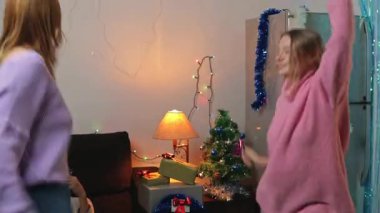 Anne ve kızı Noel ağacında dans ediyorlar.