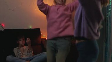 İki genç kız Noel arifesinde eğleniyor, oynuyorlar ve dans ediyorlar..