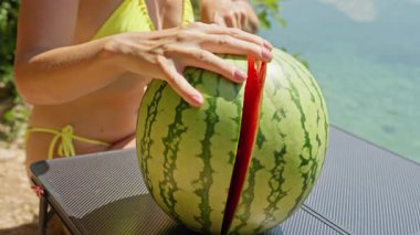 Sahilde karpuz dilimli bir kadın..