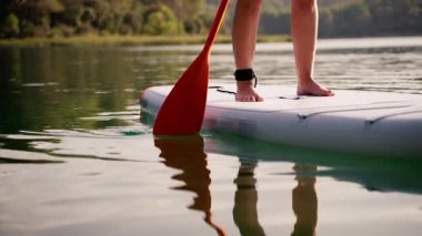 Beyaz mayo giyen kadın yemek masasında oturuyor.