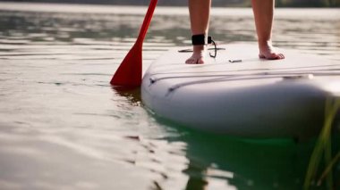 Yemek masasındaki kadın. Gölün suyunda kürek tahtası. kürek tahtası.