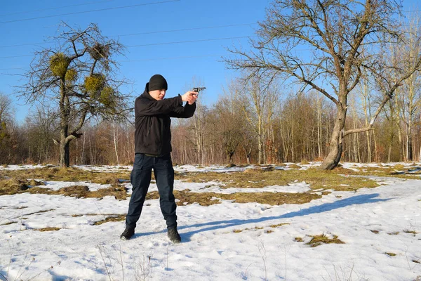 Jovem Roupas Pretas Dispara Com Uma Pistola Natureza Inverno — Fotografia de Stock