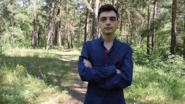 Orman arka planında gömlekli esmer bir adamın portresi.
