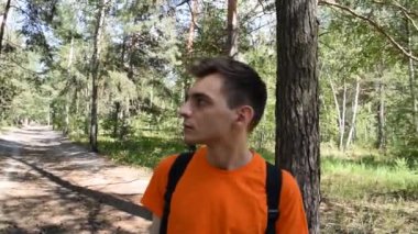 Sırt çantalı genç bir turist ormana doğru gidiyor..