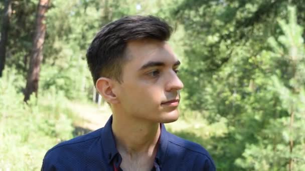 Potret Seorang Pemuda Dengan Latar Belakang Dedaunan Hijau — Stok Video