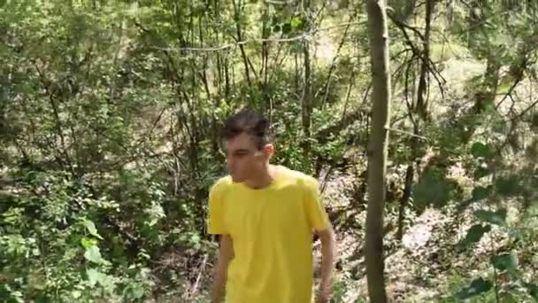 Молодий Чоловік Футболці Йде Лісом — стокове відео