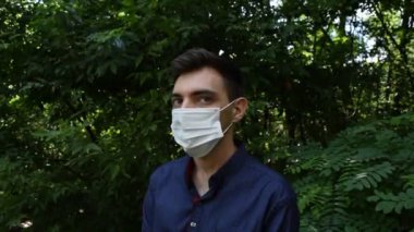 Yüzünde beyaz maske olan genç bir adamın portresi. Virüs salgını