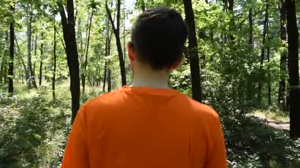 Visão Traseira Jovem Uma Camiseta Laranja Natureza Floresta — Vídeo de Stock