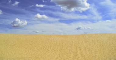 Güzel geniş kum ve bulutlu gökyüzü manzarası. Yaz, çöl