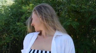 Dışarıdaki beyaz elbiseli güzel, neşeli bir kadının portresi.