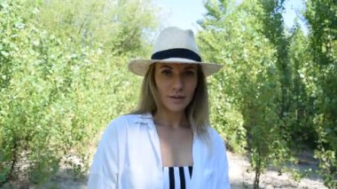 Doğada şapka takmış genç bir kızın portresi.