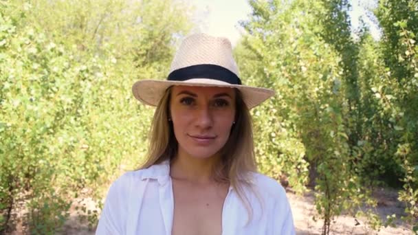 葉の間に自然に帽子をかぶった若い女性の肖像画 — ストック動画