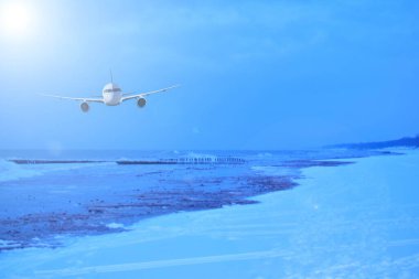 Kış okyanusunun üzerinde bir uçak. Kar plajı