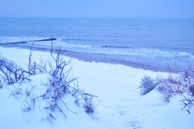 Karlı sahilden denize bak. Uzaklardan.