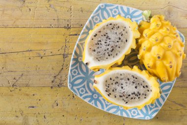 Ahşap arka planda sarı pitahaya ejder meyvesi