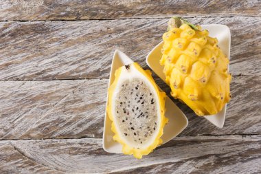 Ahşap arka planda sarı pitahaya ejder meyvesi