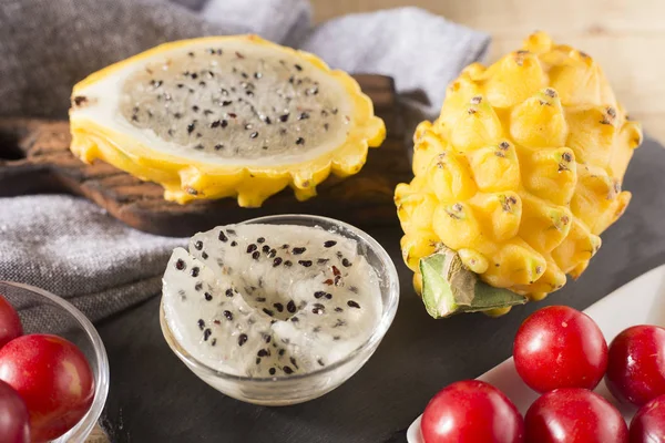 sarı pitahaya ya da ejderha meyve ve ahşap arka plan üzerinde kırmızı erik