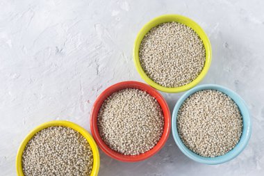 Beyaz arka plan üzerinde renkli kapta organik quinua tahıl