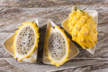 Ahşap arka planda sarı pitahaya ejder meyvesi