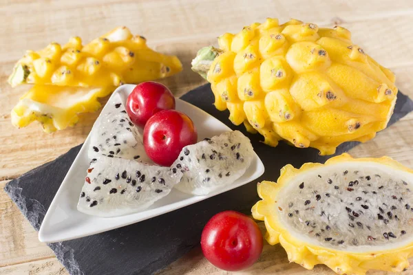 sarı pitahaya ya da ejderha meyve ve ahşap arka plan üzerinde kırmızı erik