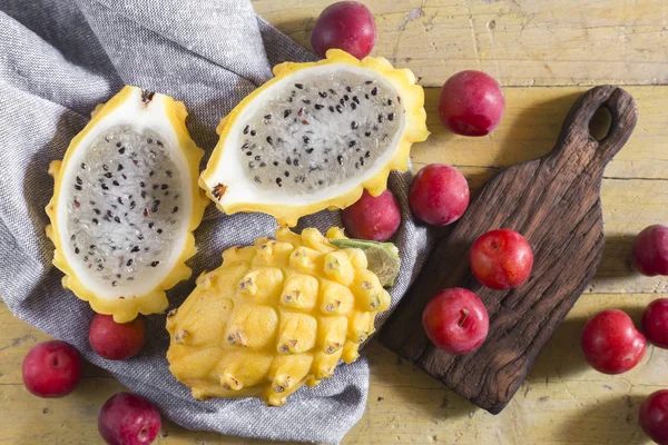 sarı pitahaya ya da ejderha meyve ve ahşap arka plan üzerinde kırmızı erik