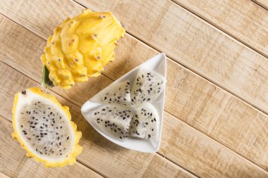 Ahşap arka planda sarı pitahaya ejder meyvesi