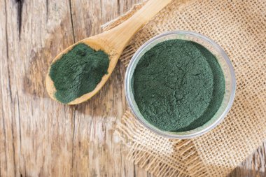 Deniz yosunu toz spirulina ahşap arka plan üzerinde