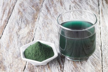 Deniz yosunu toz spirulina ahşap arka plan üzerinde
